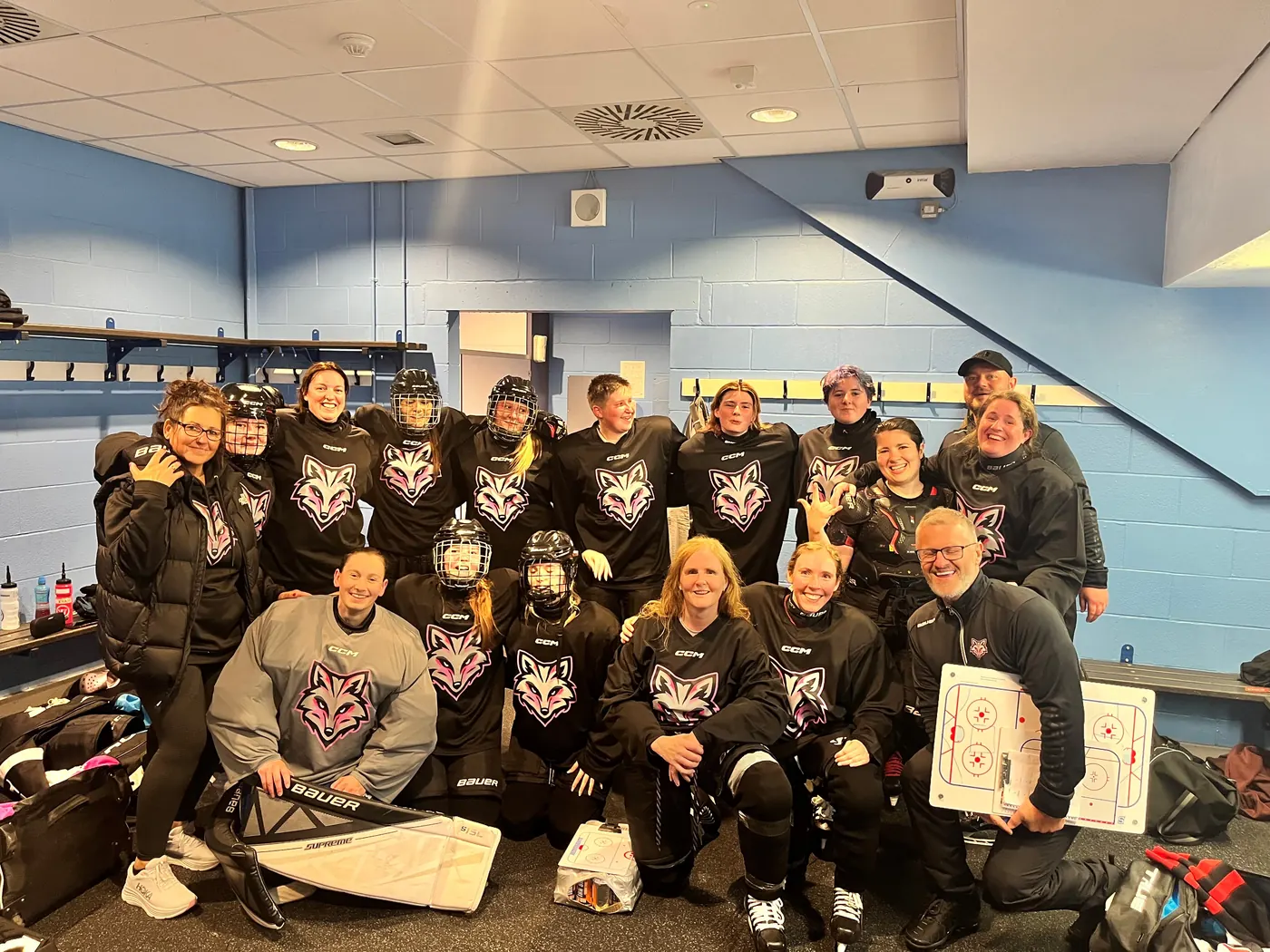 Arctic Foxes players and coaches smiling together in the changing room